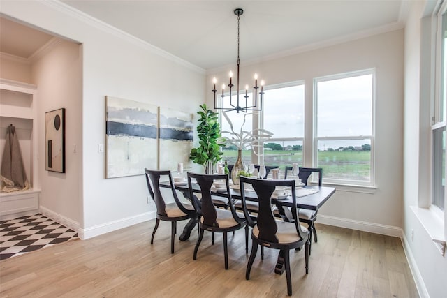 dining space with a chandelier, light wood-type flooring, and ornamental molding