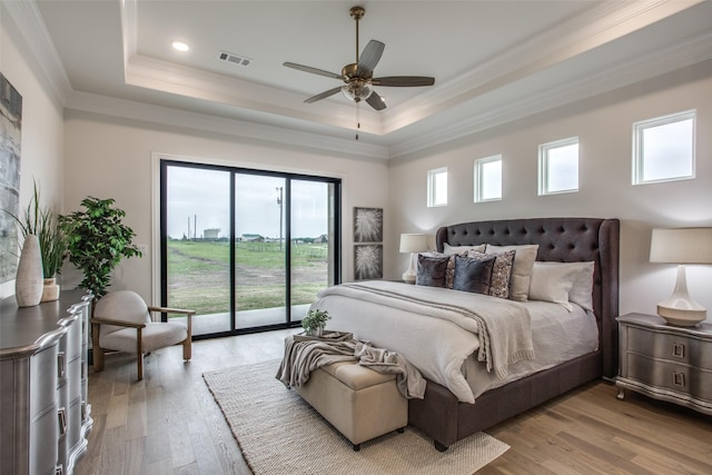 bedroom with ornamental molding, access to outside, a raised ceiling, ceiling fan, and light hardwood / wood-style flooring