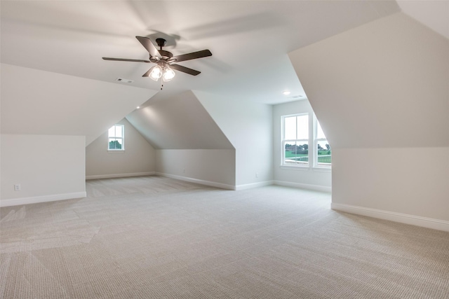 additional living space featuring ceiling fan, light colored carpet, and vaulted ceiling