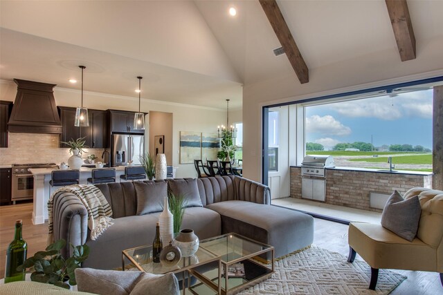 living room featuring sink, beamed ceiling, high vaulted ceiling, a notable chandelier, and light hardwood / wood-style floors