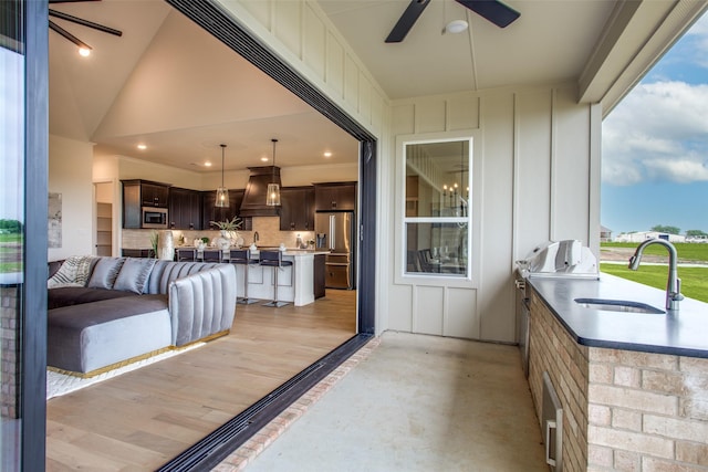 exterior space featuring an outdoor kitchen, ceiling fan, and an outdoor wet bar