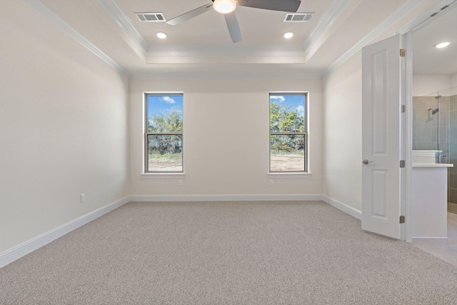 spare room with light carpet, a tray ceiling, ceiling fan, and crown molding