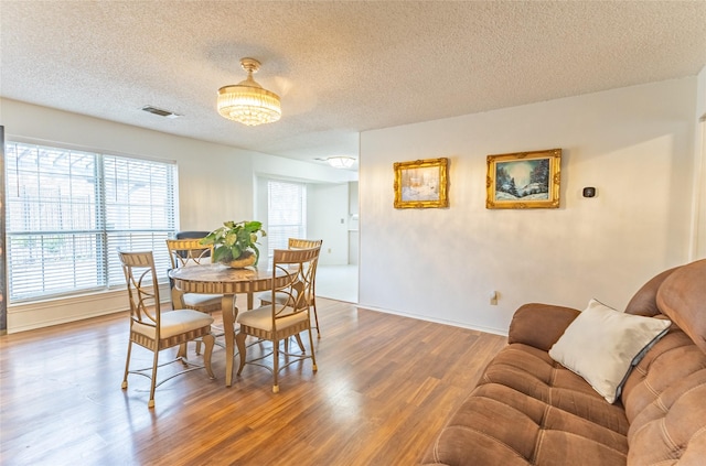 dining area featuring hardwood / wood-style floors and a textured ceiling