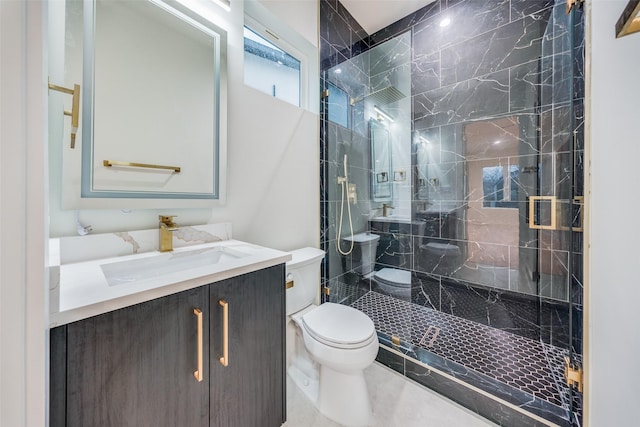 bathroom featuring vanity, a shower with shower door, and toilet