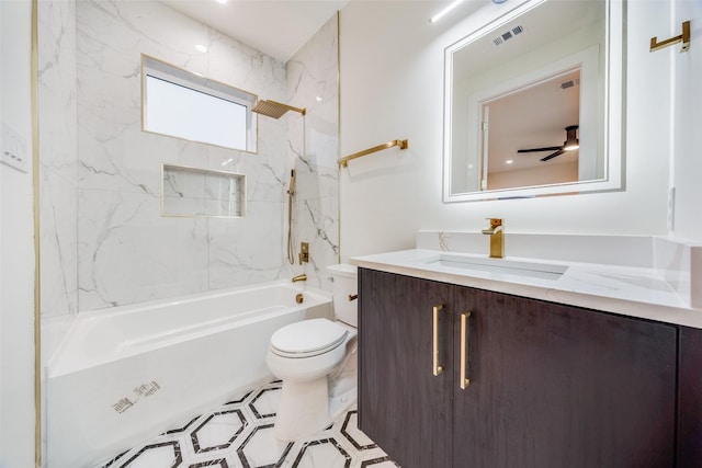 full bathroom featuring vanity, ceiling fan, tile patterned flooring, toilet, and tiled shower / bath