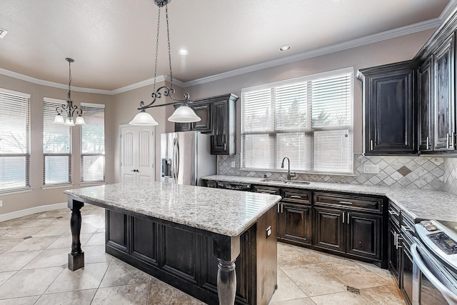 kitchen with a center island, decorative backsplash, appliances with stainless steel finishes, ornamental molding, and a sink