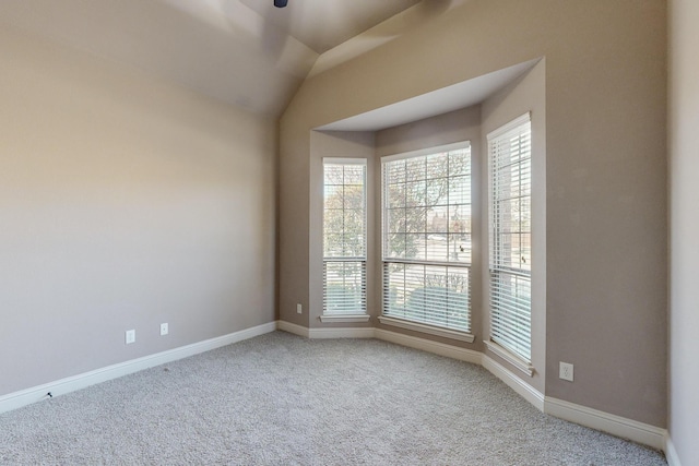 unfurnished room featuring carpet flooring and vaulted ceiling