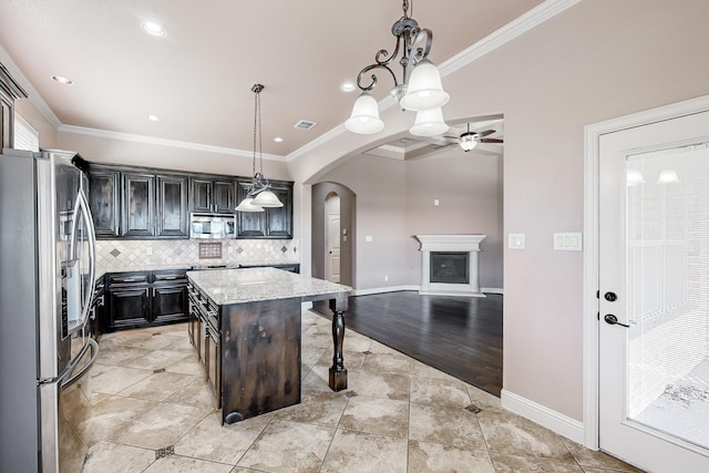 kitchen featuring a breakfast bar, light stone countertops, appliances with stainless steel finishes, decorative light fixtures, and a kitchen island