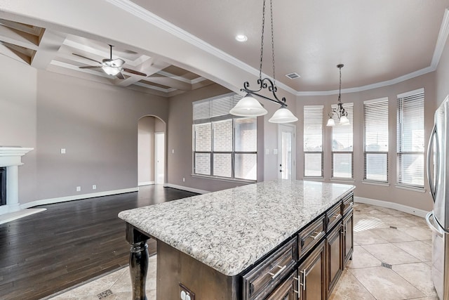 kitchen with beam ceiling, a center island, coffered ceiling, pendant lighting, and ceiling fan with notable chandelier