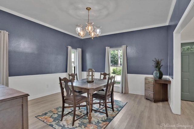 dining space with a notable chandelier, light hardwood / wood-style floors, and crown molding