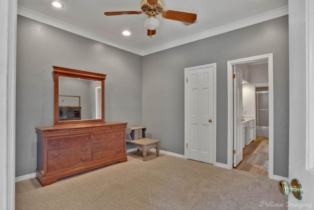 bedroom featuring ceiling fan, light colored carpet, crown molding, and connected bathroom