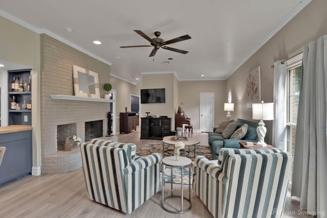 living room with ceiling fan, light hardwood / wood-style floors, ornamental molding, and a fireplace