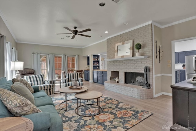 living room with ceiling fan, light hardwood / wood-style flooring, crown molding, and a brick fireplace