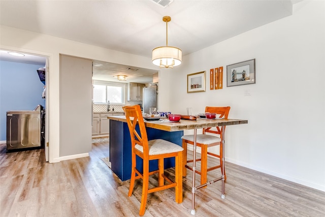 dining area with light hardwood / wood-style flooring and sink