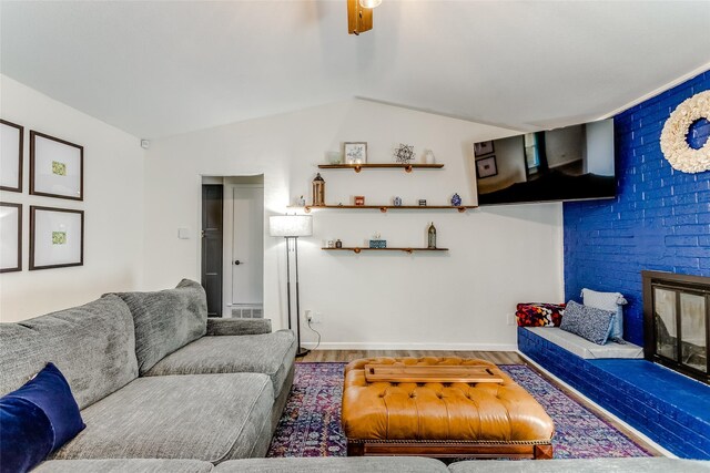 living room featuring hardwood / wood-style flooring, ceiling fan, and vaulted ceiling