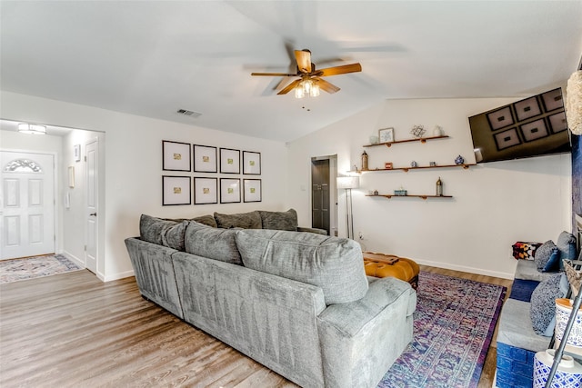 living room with light hardwood / wood-style flooring, ceiling fan, and lofted ceiling