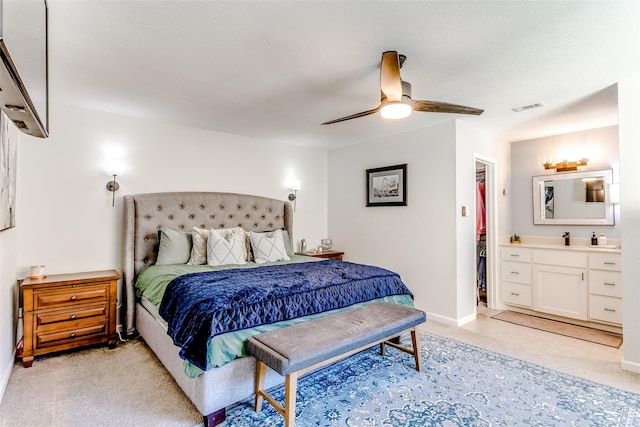 carpeted bedroom with ceiling fan, a walk in closet, connected bathroom, and a closet