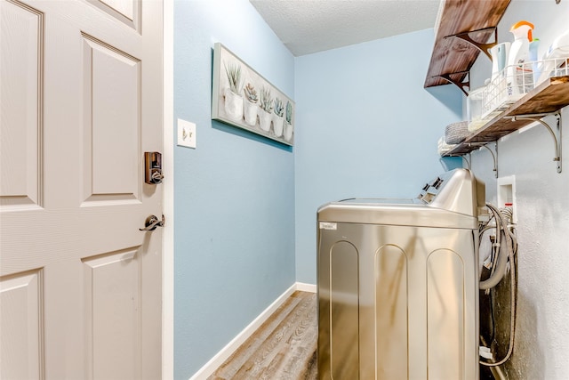 laundry area with hardwood / wood-style flooring, separate washer and dryer, and a textured ceiling