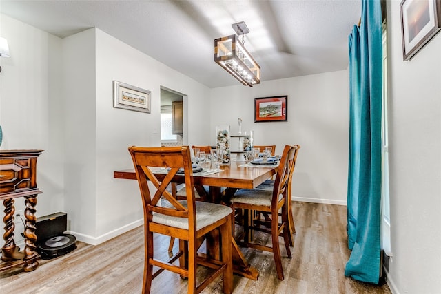 dining room featuring a textured ceiling and light wood-type flooring