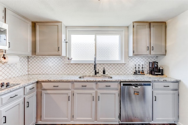 kitchen with tasteful backsplash, light stone counters, stainless steel dishwasher, gas stovetop, and sink