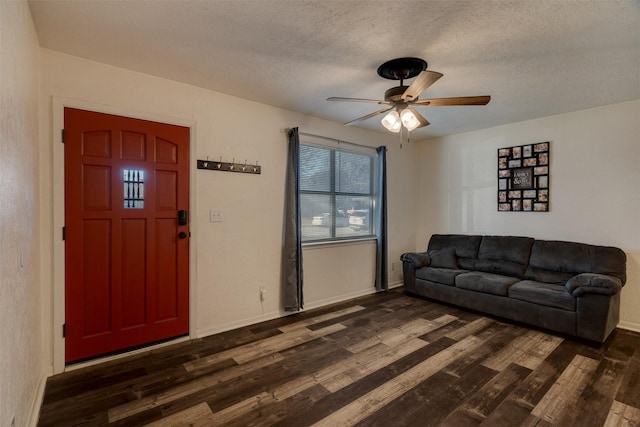 living room with dark hardwood / wood-style floors, a textured ceiling, and ceiling fan