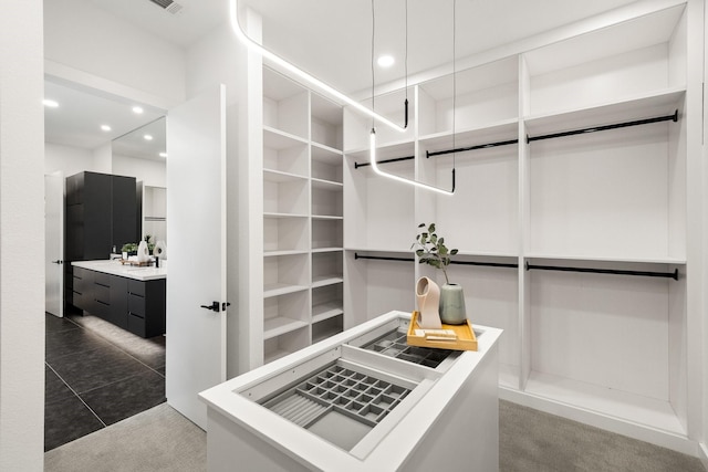 walk in closet featuring dark tile patterned floors