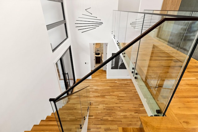 stairs featuring hardwood / wood-style floors and a towering ceiling