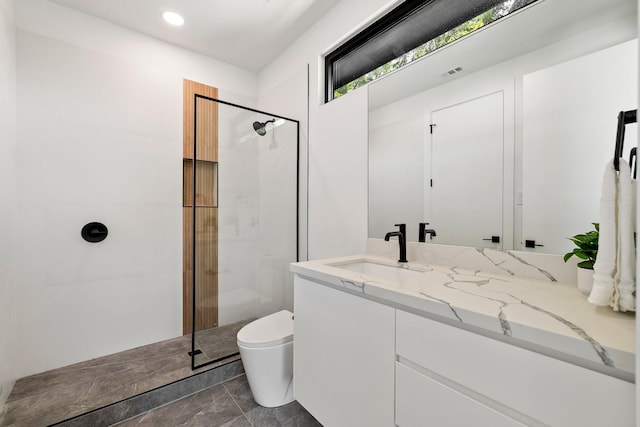 bathroom with vanity, toilet, and a tile shower