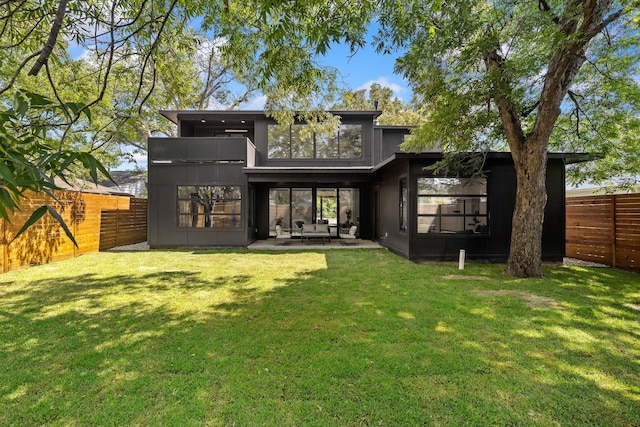 rear view of property with a lawn and a patio area