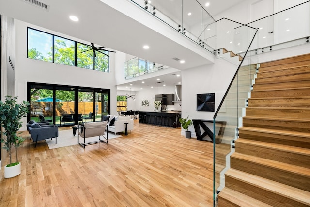 living room featuring wood-type flooring and a high ceiling