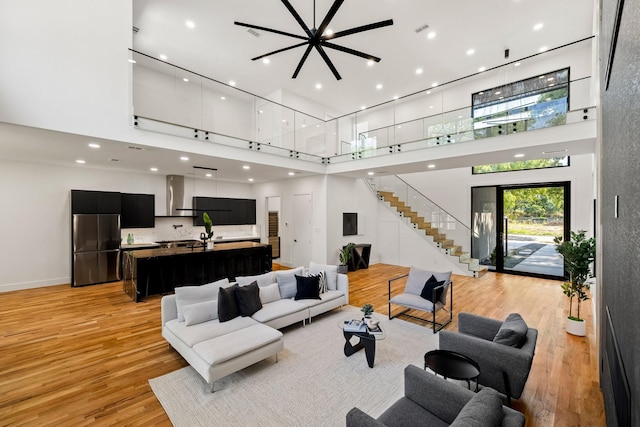 living room featuring a towering ceiling and light hardwood / wood-style floors