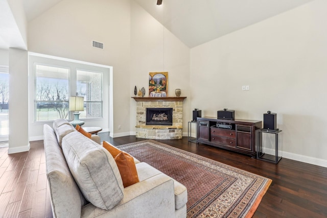 living room featuring a fireplace, dark hardwood / wood-style flooring, and high vaulted ceiling