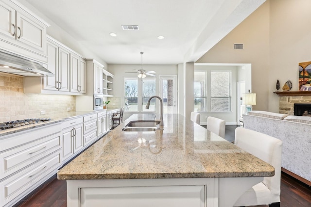 kitchen with stainless steel appliances, sink, a breakfast bar area, and tasteful backsplash