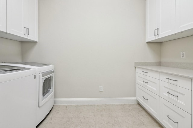 laundry room featuring washer and dryer, cabinets, and light tile patterned flooring