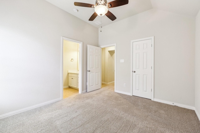 unfurnished bedroom with ensuite bath, ceiling fan, high vaulted ceiling, light carpet, and a closet