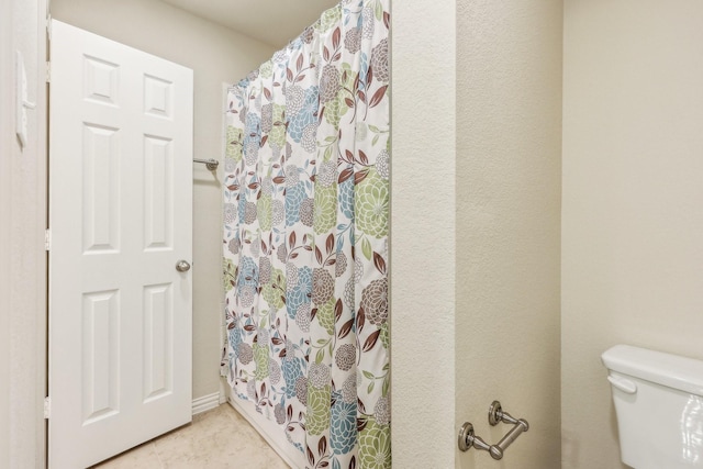 bathroom with tile patterned floors and toilet