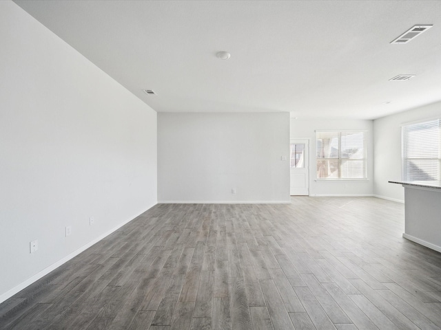 unfurnished room with dark wood-type flooring