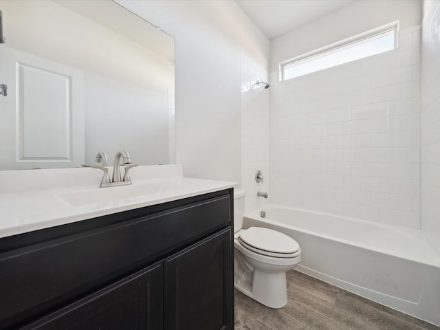 full bathroom featuring hardwood / wood-style floors, vanity, toilet, and washtub / shower combination