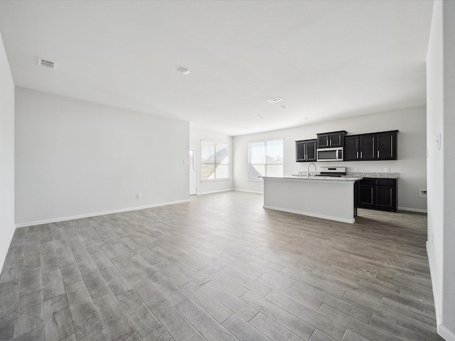 unfurnished living room with light wood-type flooring and sink