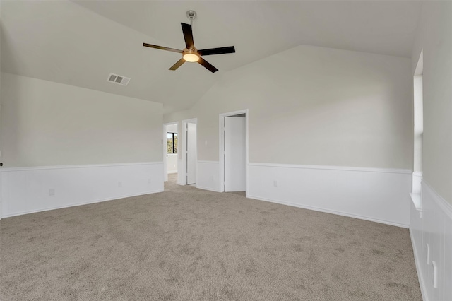 unfurnished room with light carpet, vaulted ceiling, and ceiling fan