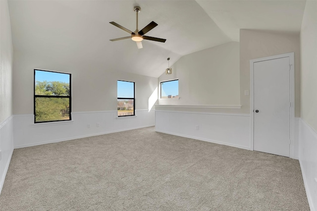 unfurnished room featuring ceiling fan, light colored carpet, and vaulted ceiling