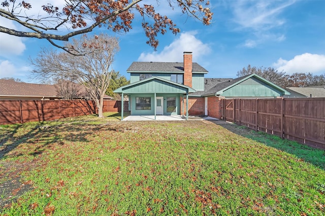 rear view of house featuring a lawn and a patio area