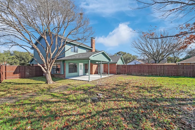 back of house with a patio area and a yard