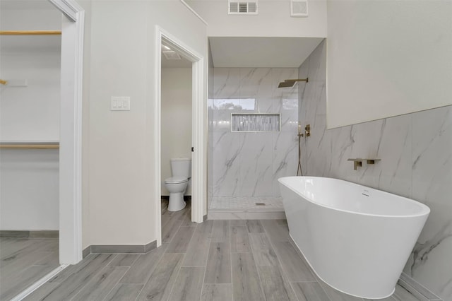 bathroom featuring separate shower and tub, tile walls, and toilet