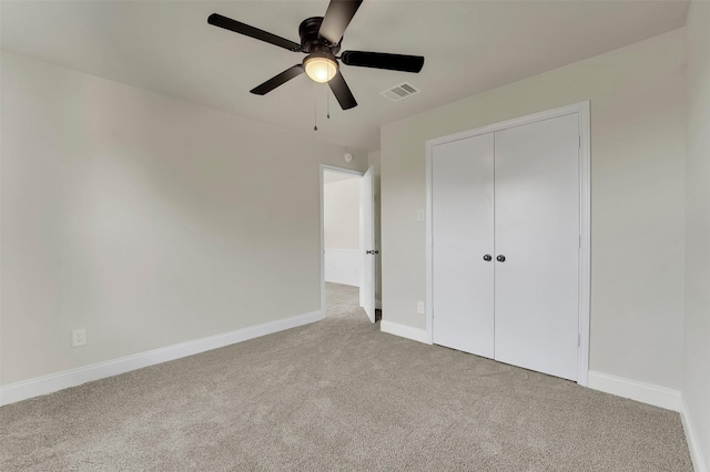 unfurnished bedroom featuring ceiling fan, a closet, and carpet