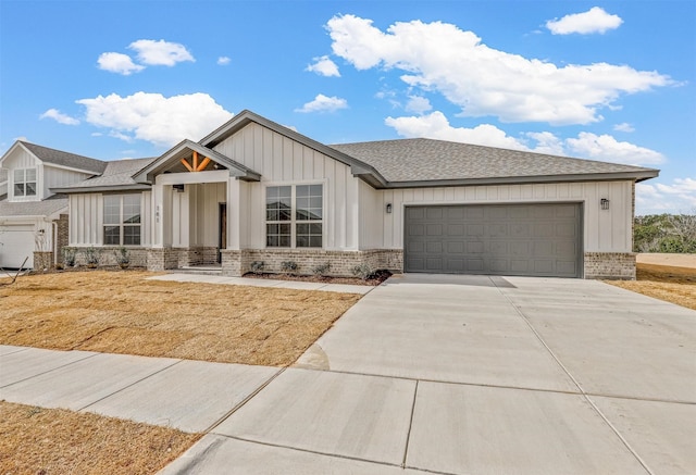 modern farmhouse featuring board and batten siding, an attached garage, brick siding, and driveway