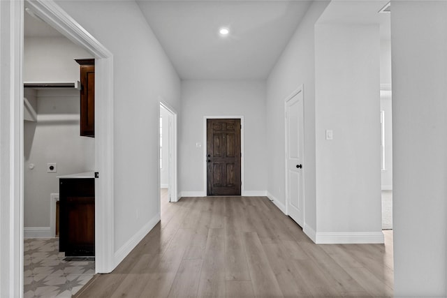 foyer entrance featuring baseboards and light wood finished floors