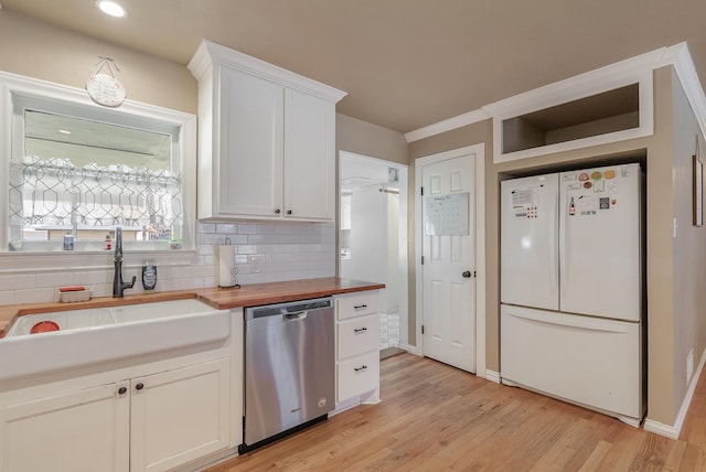 kitchen with dishwasher, white cabinets, sink, white fridge, and butcher block counters