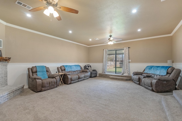 carpeted living room with ceiling fan and ornamental molding