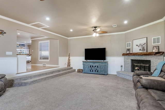 carpeted living room featuring a fireplace, ceiling fan, and ornamental molding